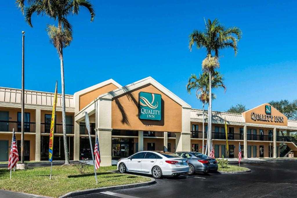 Quality Inn Fort Pierce I-95 exterior with palms and flags